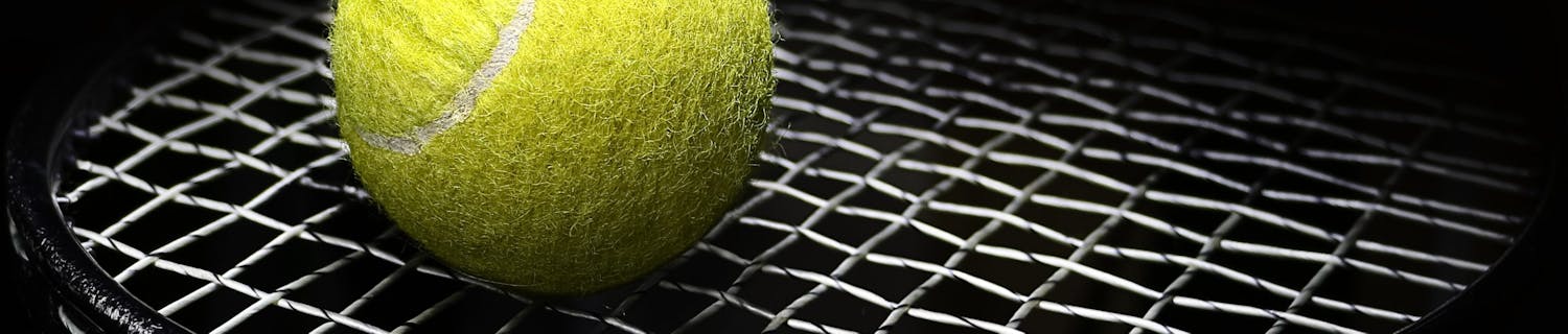 Tennis,Ball,On,A,Tennis,Racket,Net,On,A,Black